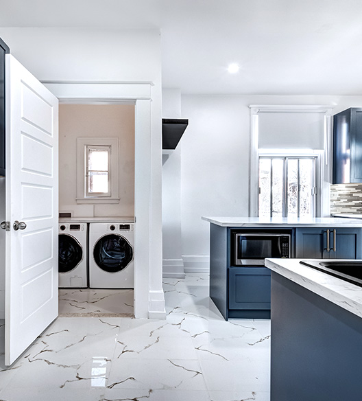 Modern home interior with a kitchen and a nearby laundry nook with a washer and dryer